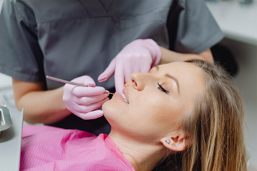 a girl is getting her teeth examined