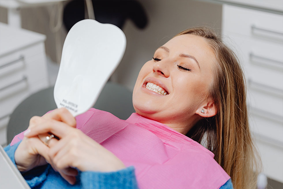 patient checking her teeth in a mirror