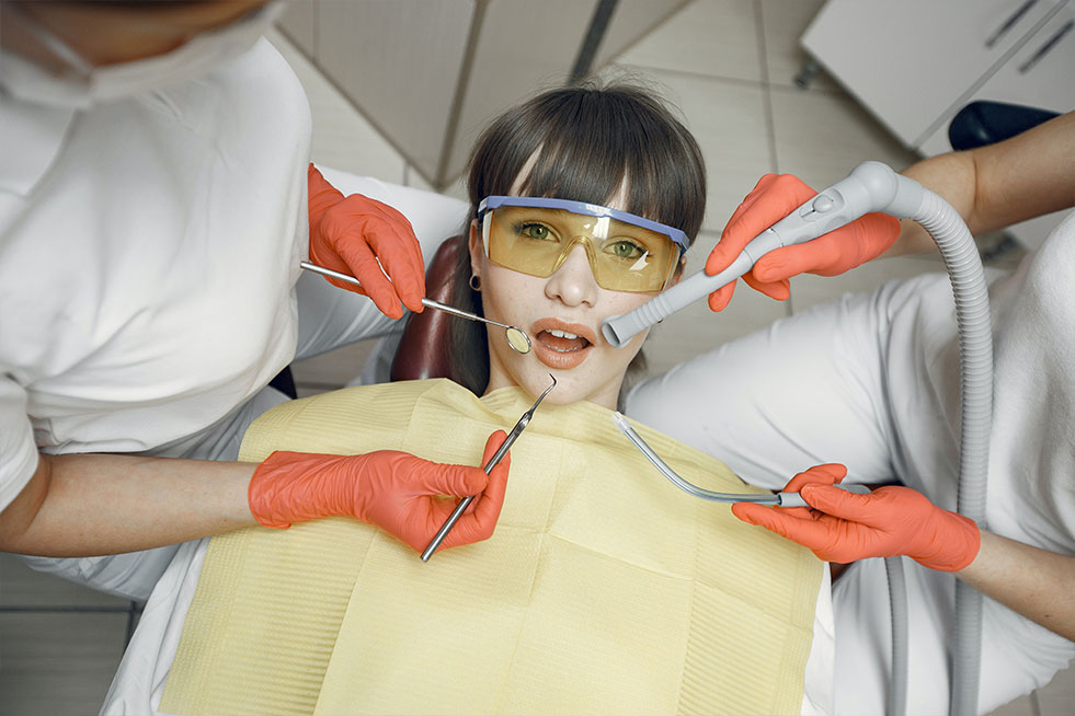 a dentist is doing teeth whitening of a girl